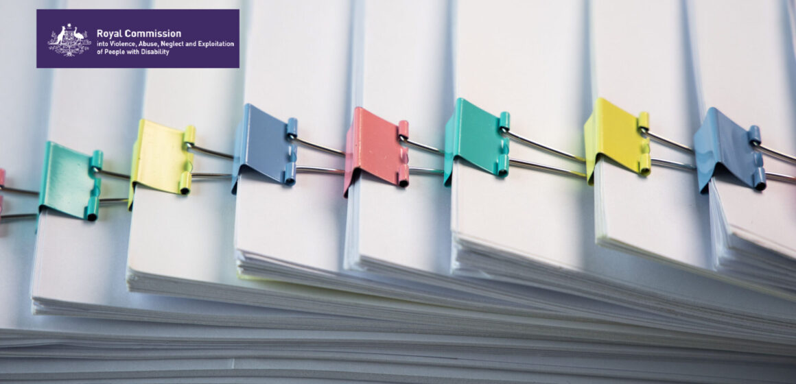 Stacks of paper files with colourful bulldog clips. Australian government logo in the corner and Disability royal commission in text